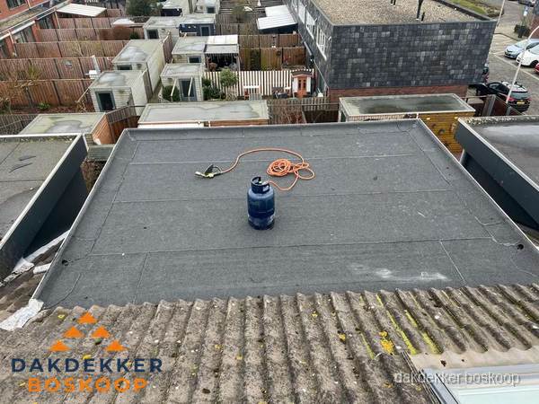 Plat dak met nieuwe bitumen dakbedekking en brandgereedschap in Boskoop