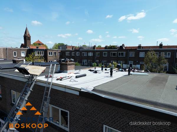 Dakdekkers aan het werk op plat dak in Boskoop