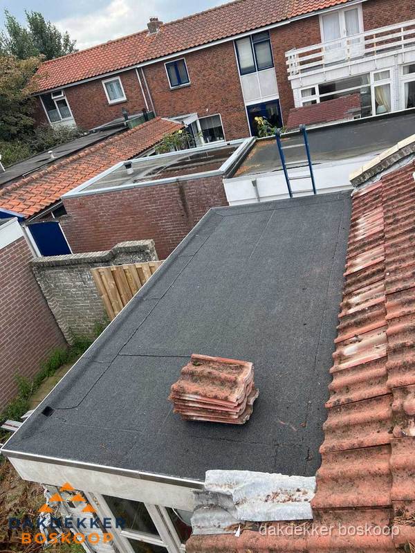 Plat dak aanbouw met bitumen naast schuin pannendak in Boskoop Plat dak aanbouw met bitumen naast schuin pannendak in Boskoop