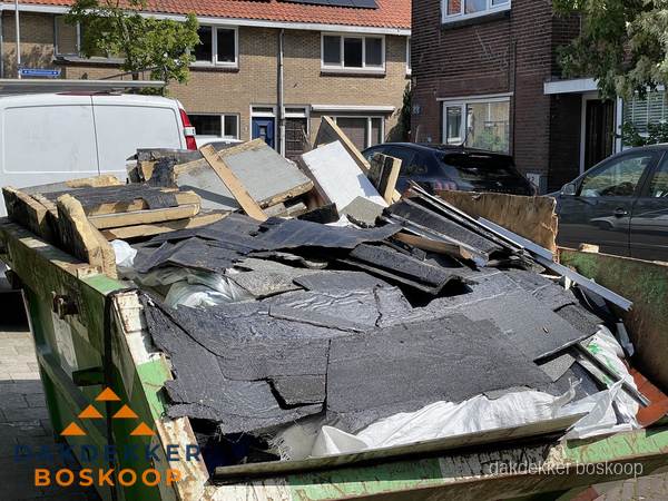 Afvalcontainer met gesloopt dakmateriaal tijdens dakkapel renovatie in Boskoop Afvalcontainer met gesloopt dakmateriaal tijdens dakkapel renovatie in Boskoop