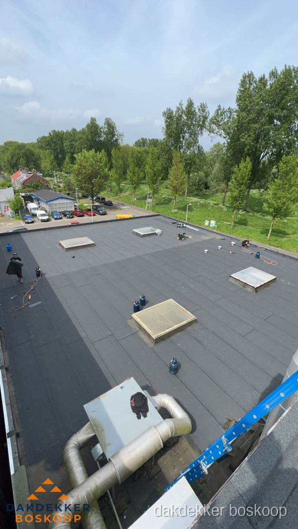 Dakdekker aan het werk op groot plat dak met bitumen in Boskoop Dakdekker aan het werk op groot plat dak met bitumen in Boskoop