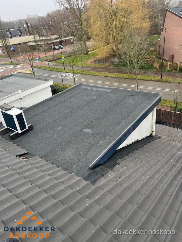 Plat dak met bitumen dakbedekking naast schuin pannendak in Boskoop