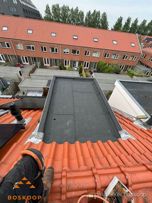 Bitumen dak reparatie op plat dak tussen dakpannen in Boskoop