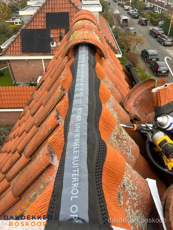 Dakdekker vervangt nokvorst met ruiterrol op pannendak in Boskoop
