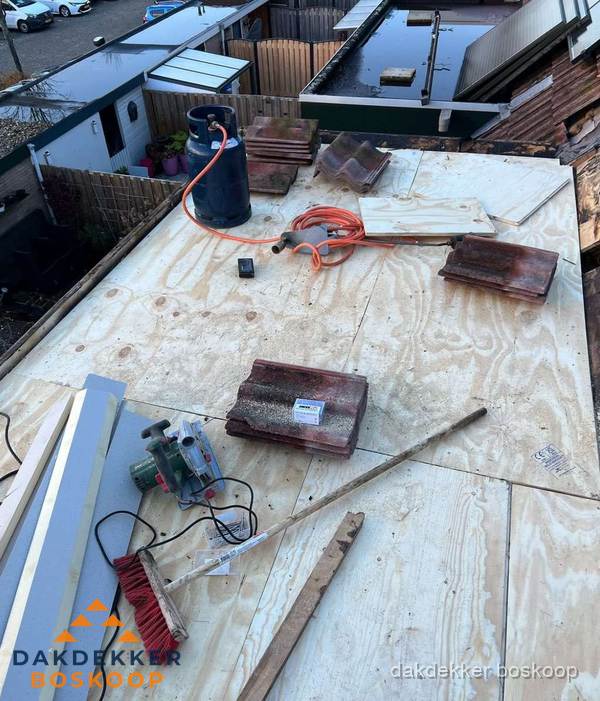 Dakreparatie werkzaamheden op plat dak met gereedschap in Boskoop